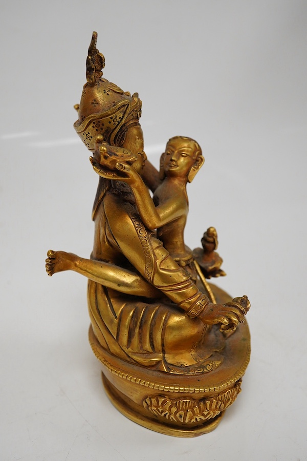 A Tibetan gilt bronze figure of a deity and consort, 15cm high. Condition - good